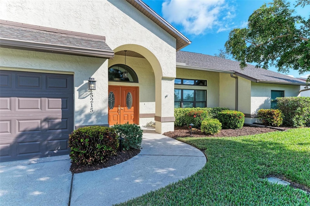 property entrance featuring a lawn