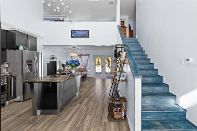 kitchen with a center island, french doors, light hardwood / wood-style flooring, a chandelier, and appliances with stainless steel finishes