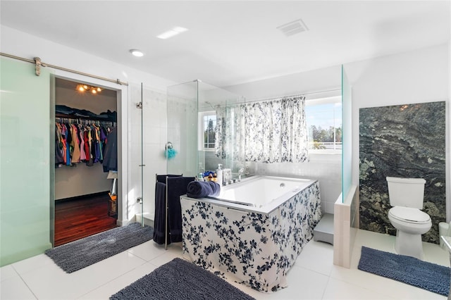 bathroom with tile patterned floors, toilet, and independent shower and bath