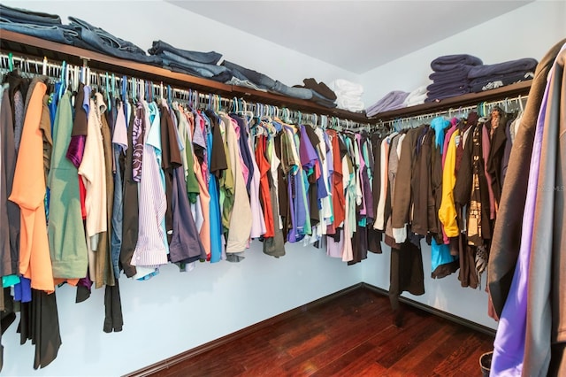 walk in closet with dark hardwood / wood-style floors