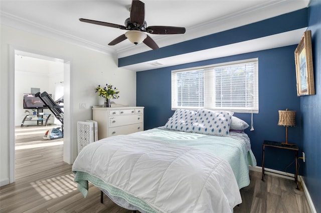 bedroom with ceiling fan, crown molding, and hardwood / wood-style flooring