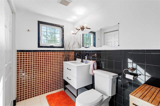 bathroom featuring tile patterned flooring, vanity, tile walls, and toilet