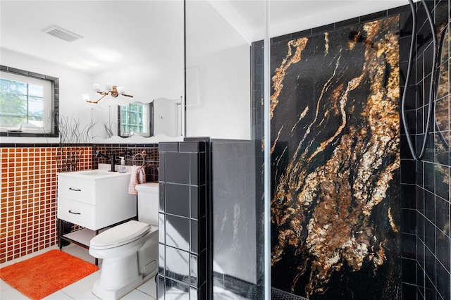 bathroom with tile patterned floors, vanity, toilet, and tile walls