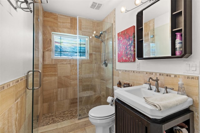 bathroom featuring walk in shower, vanity, toilet, and tile walls