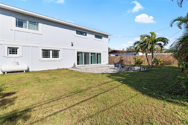 back of property with a yard and a patio area