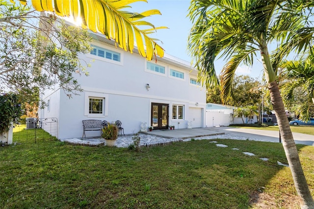 rear view of house with a lawn, french doors, a patio, and central AC unit