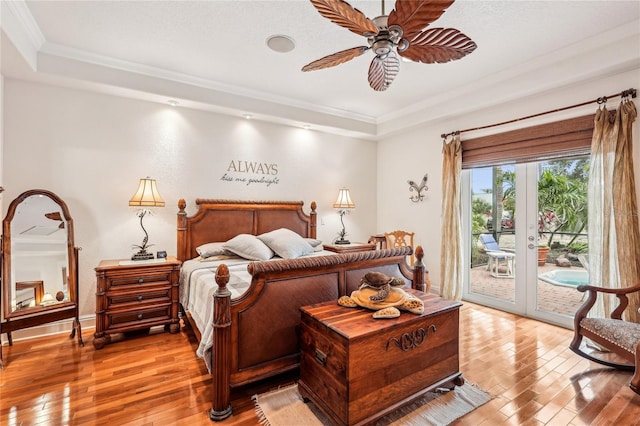 bedroom with light hardwood / wood-style floors, ceiling fan, a raised ceiling, access to outside, and french doors