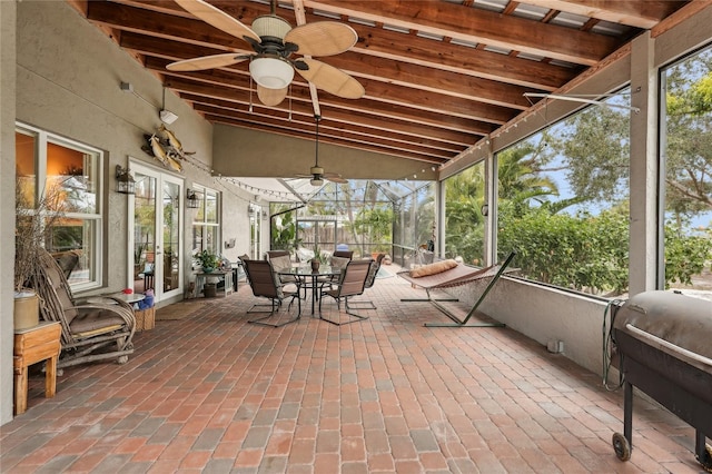 unfurnished sunroom featuring ceiling fan and lofted ceiling