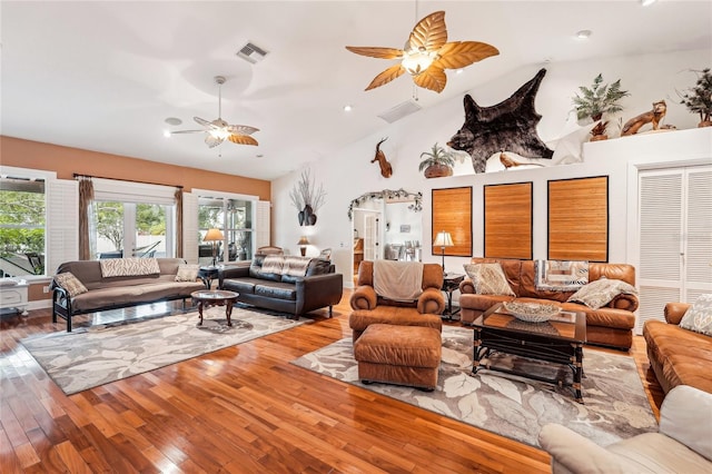 living room with hardwood / wood-style floors, high vaulted ceiling, and ceiling fan