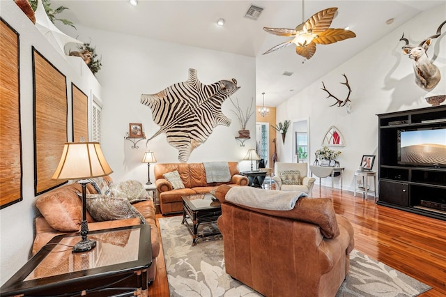 living room with ceiling fan, high vaulted ceiling, and light wood-type flooring