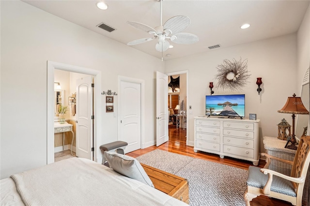 bedroom with ceiling fan, connected bathroom, and hardwood / wood-style floors