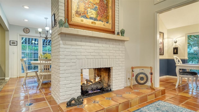 tiled living room with a fireplace, a chandelier, and plenty of natural light