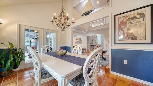 tiled dining space with french doors, a high ceiling, and an inviting chandelier