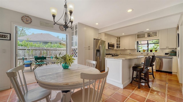 tiled dining room featuring sink and an inviting chandelier