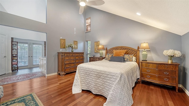 bedroom with hardwood / wood-style floors, high vaulted ceiling, french doors, ceiling fan, and access to exterior