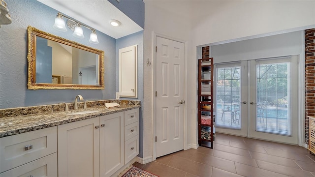 bathroom featuring tile patterned flooring, french doors, and vanity