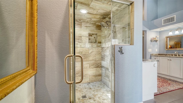 bathroom featuring tile patterned flooring, vanity, and an enclosed shower