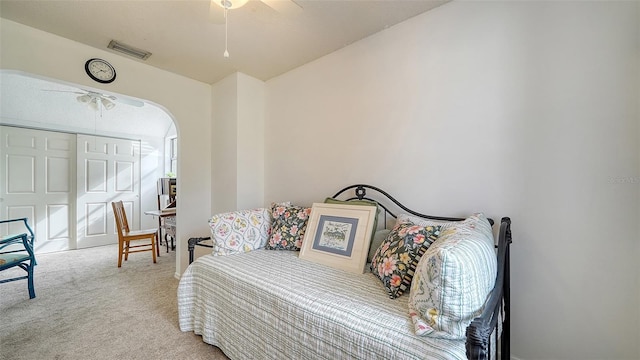 bedroom with ceiling fan, a closet, and light colored carpet