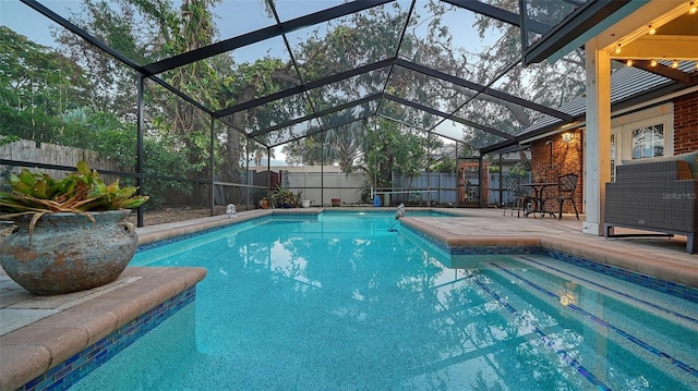 view of pool featuring glass enclosure and a patio area