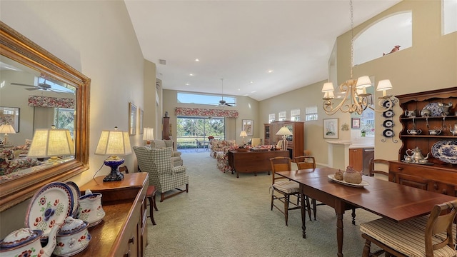 dining room featuring carpet, a towering ceiling, and ceiling fan with notable chandelier