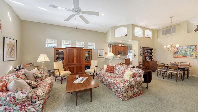 living room with light carpet, high vaulted ceiling, and ceiling fan with notable chandelier