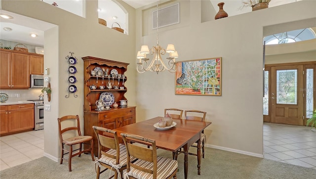 tiled dining room with a towering ceiling and an inviting chandelier