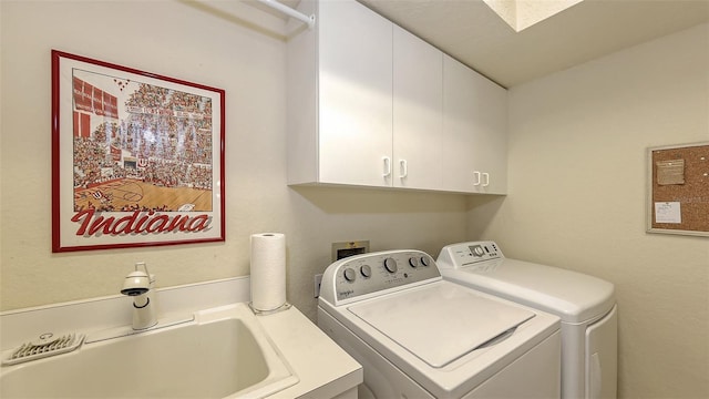 laundry area featuring cabinets, washer and dryer, and sink