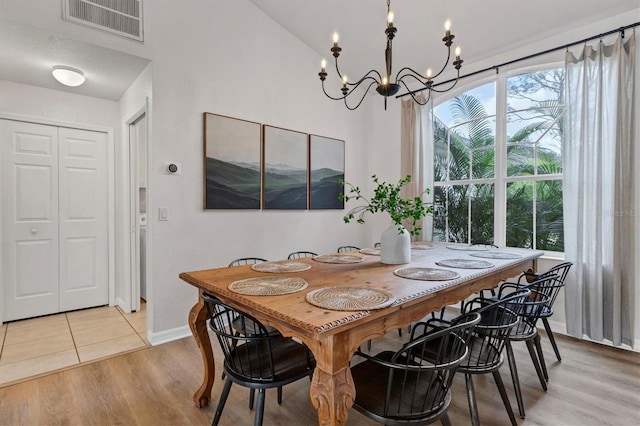 dining space with light wood-type flooring and a chandelier