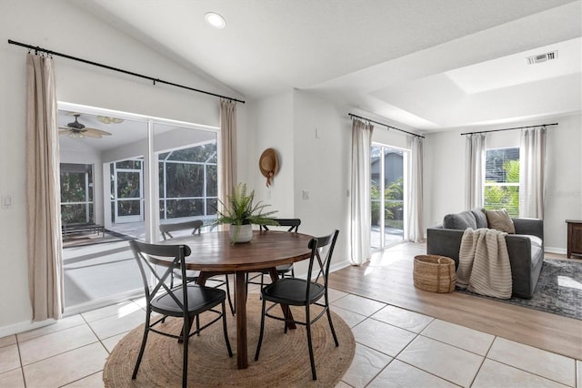 tiled dining space with ceiling fan and lofted ceiling