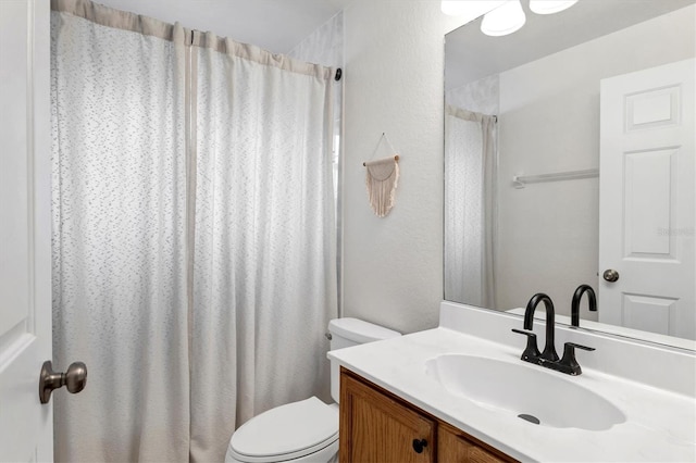 bathroom featuring vanity, a shower with shower curtain, and toilet