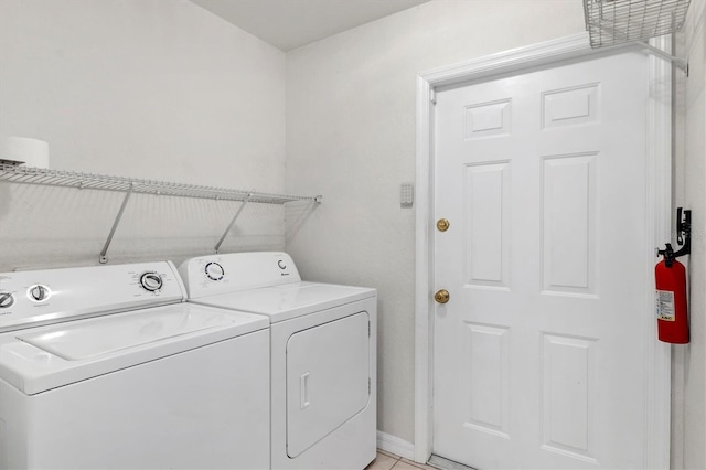 laundry room with washing machine and clothes dryer and light tile patterned floors