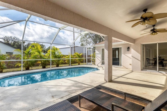 view of swimming pool with glass enclosure, ceiling fan, and a patio area