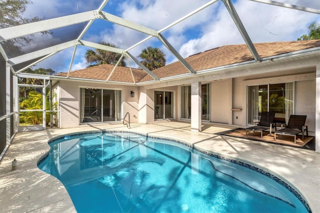 back of house featuring glass enclosure and a patio area