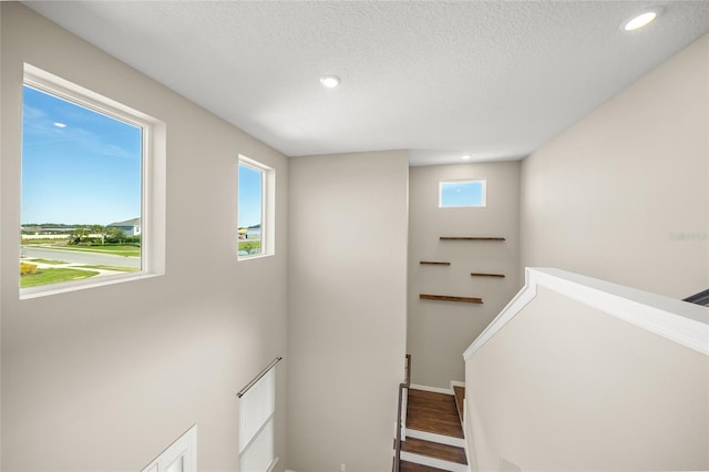 stairway featuring hardwood / wood-style flooring and a textured ceiling