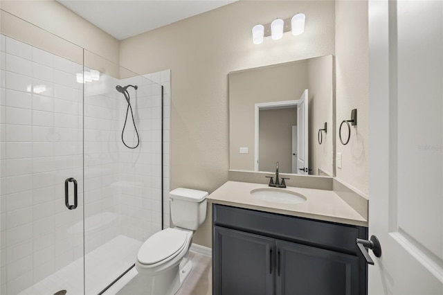 bathroom with toilet, vanity, and a shower with door