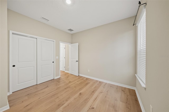 unfurnished bedroom with light hardwood / wood-style floors and a closet