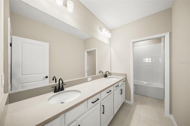 bathroom featuring tile patterned floors, a textured ceiling, vanity, and washtub / shower combination