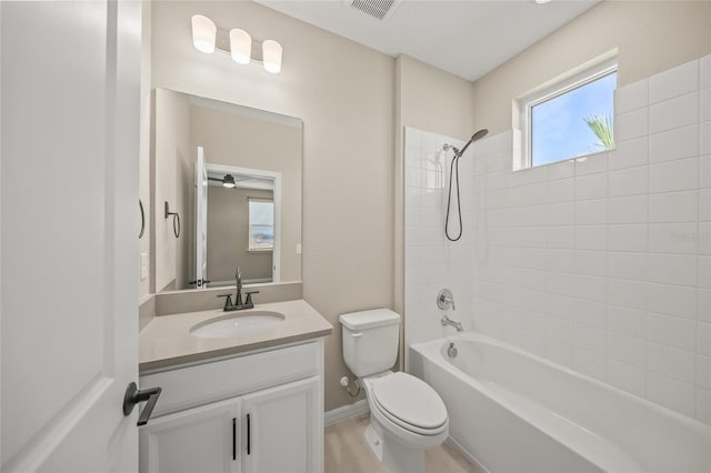 full bathroom with tiled shower / bath combo, toilet, and vanity