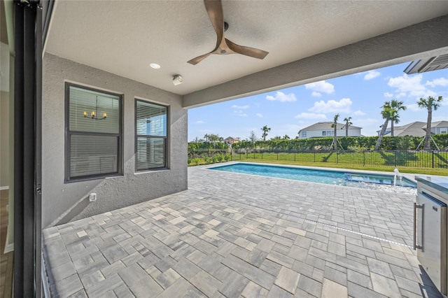 view of swimming pool with ceiling fan and a patio area