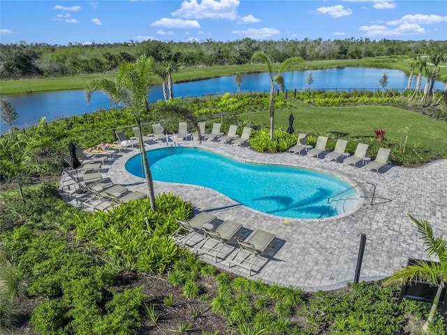 view of pool with a patio area, a water view, and a lawn