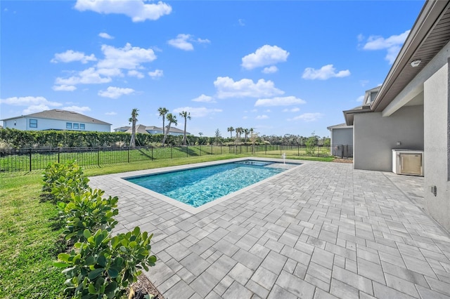 view of pool with a patio and a yard