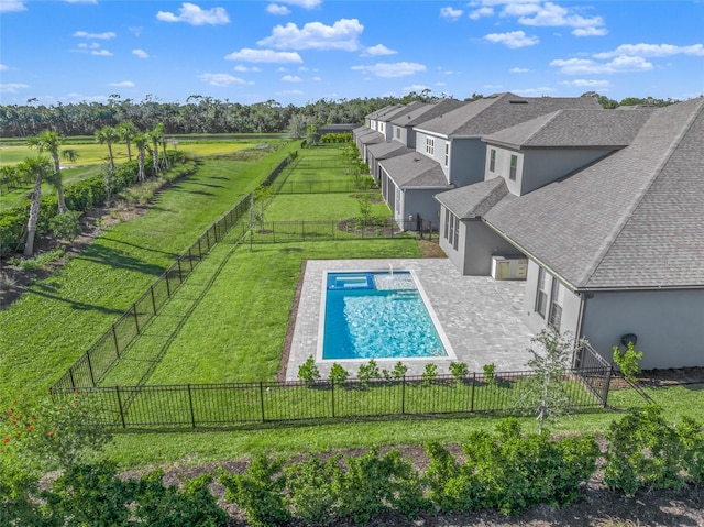 view of swimming pool with a rural view, a yard, and a patio