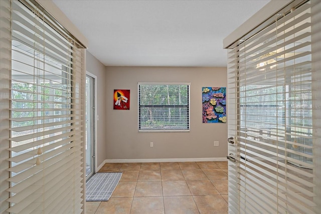 doorway to outside with light tile patterned floors