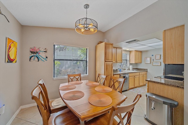 dining space featuring light tile patterned floors, sink, and a notable chandelier