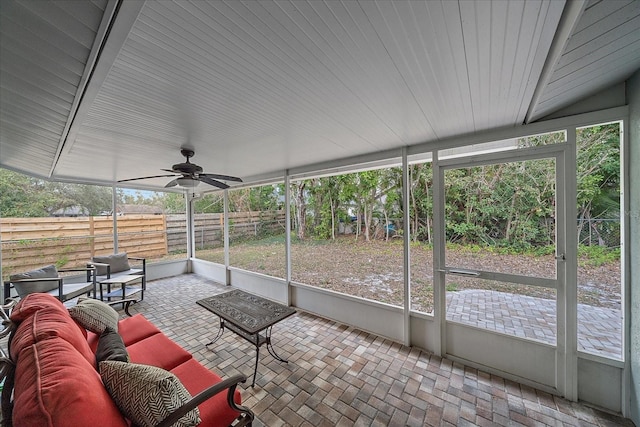 unfurnished sunroom with ceiling fan