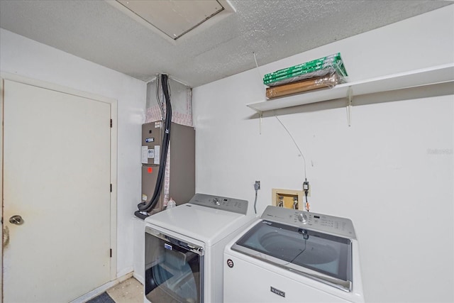 clothes washing area with washing machine and clothes dryer and a textured ceiling