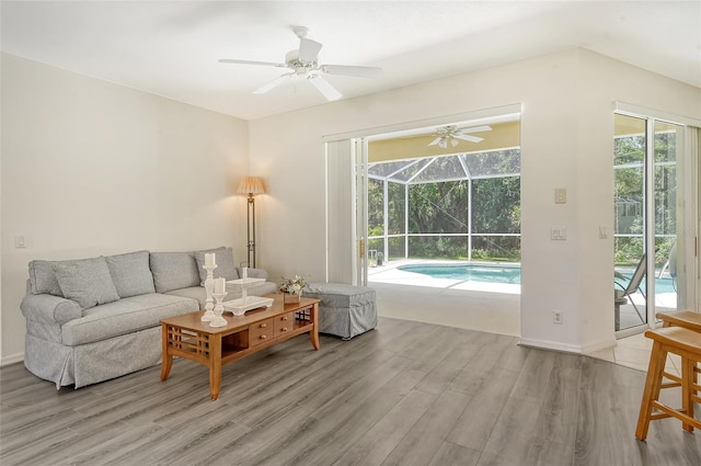 living room with ceiling fan, plenty of natural light, and light hardwood / wood-style floors