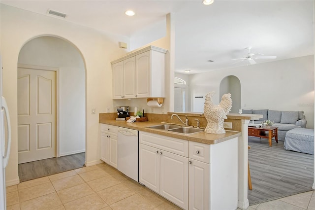 kitchen with white dishwasher, sink, ceiling fan, light tile patterned flooring, and kitchen peninsula