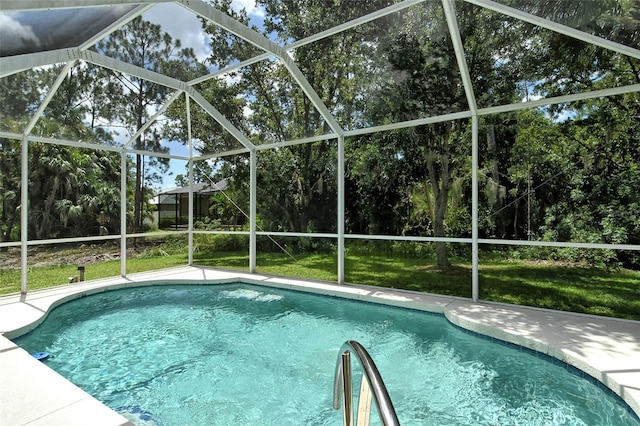 view of pool with a lawn and glass enclosure