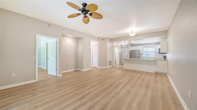 unfurnished living room featuring ceiling fan and light wood-type flooring